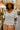 White chic crochet short sleeve top styled with floral pants and straw hat.