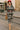 Woman walking in abstract floral print midi dress with red belt and espadrilles, city street, morning