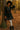 Woman standing in polka dot plaid trim babydoll dress, red belt, white tights, black boots, autumn forest