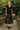 Walking in black sweater vest with paisley midi skirt and black shoes, in garden pavilion, soft daylight