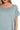 Close-up of blue grey scoop neck t-shirt dress with rolled sleeves and pocket detail