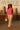 Bright pink tee with tailored cream pants and heels styled for sunset rooftop