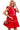 Woman wearing a red dress with white trim holding a small handbag.