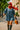Denim mini dress with red scarf and gloves styled for bold fall city streetwear