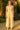 Woman standing in Embroidered Jumpsuit with espadrilles, by lavender bush, golden sunset light