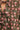 Close-up of a floral patterned fabric with pink and green flowers on a brown background.