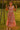Woman in floral tiered maxi dress with espadrilles, standing on swing at sunset in grassy field