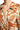 Close-up of rust floral pattern and button placket on lightweight polyester