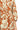 Close-up of a dress with a floral pattern in orange and white.