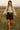 Woman in oatmeal linen drawstring top with fringe leather skirt and cowboy boots, prairie sunset.