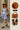 Gingham dress with rust hat, leather loafers, and saddle bag styled for city stroll.