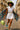 White shirt styled as mini dress with chain belt, green bag, and blue heels for playful vibe