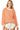 Woman wearing an orange and white striped long-sleeve top with white shorts on a white background