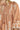 Brown dress with white floral patterns and tassels on a close-up view