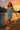 Woman in a teal romper running joyfully by a lake at sunset