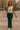 Fashion model smiling in sand beige tie front cropped sweater vest with green flared pants, city square.