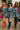 Three women wearing washed denim mini dresses styled with boots, bold accessories, and layered fall pieces
